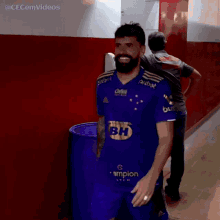 a man with a beard wearing a blue shirt that says bh
