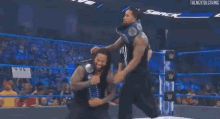 a man is carrying another man on his shoulders in a wrestling ring .