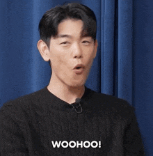 a man is wearing a black sweater and says woohoo