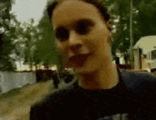 a close up of a person 's face with a blurry background of trees .