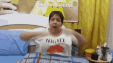 a woman is wearing a night shirt while laying on a bed