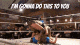 a woman is wrestling another woman in a wrestling ring while a crowd watches .