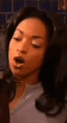 a close up of a woman 's face with her mouth open and her eyes closed .