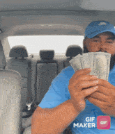 a man in a blue shirt is holding a bunch of money