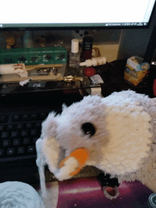 a stuffed animal sits on a desk next to a keyboard and a box of oreo cookies