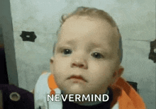 a baby is making a funny face and says `` nevermind '' .