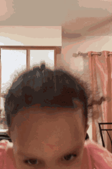 a close up of a baby 's head with a window behind it