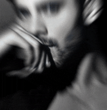 a blurry black and white photo of a man with headphones on