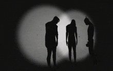 a man and two women are standing in a dark room in silhouette