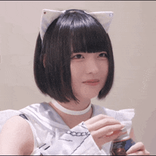a girl wearing a cat ear headband is holding a bottle of soda