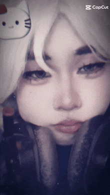 a close up of a person 's face with headphones and a hello kitty sticker on her head
