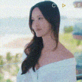 a woman in a white off the shoulder top is standing on a balcony .