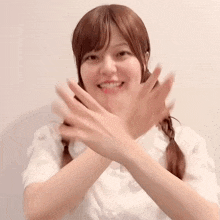 a woman in a white shirt has her hands crossed