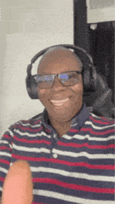 a bald man wearing glasses and headphones is smiling while holding a banana .