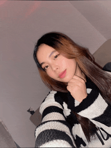 a girl wearing a black and white striped sweater with the letter n on it