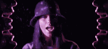 a woman wearing a bucket hat is surrounded by purple lips