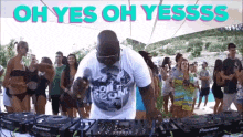 a dj is playing music in front of a crowd of people with the words oh yes oh yesss written above him .
