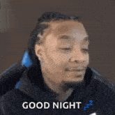 a man is sitting in a chair with his eyes closed and says good night .