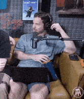 a man wearing headphones is sitting on a couch with a laptop in front of him
