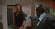 two men are fighting each other in a room .