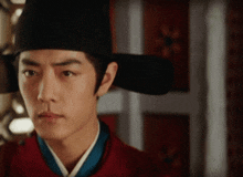 a man wearing a black hat and a red jacket