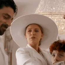 a woman in a white hat is standing next to a man