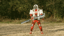 a red and white superhero is holding a large sword