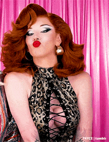 a woman with red hair is wearing a lace up top with a plunging neckline