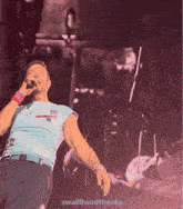 a man is singing into a microphone with the words swallowwedthesea below him