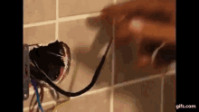 a person is fixing a broken electrical outlet on a wall .