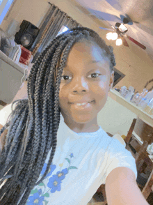 a girl with braids and a white shirt with blue flowers