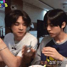 two young men are sitting at a table with a sign that says ws club on it