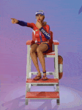 a lifeguard sitting in a chair with the word rescue on her sleeve