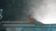 a man in a red mask is sitting in a bathtub