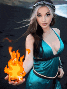 a woman in a blue dress is holding a flame in her hand