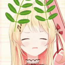 a girl with blonde hair and green leaves on her head is making a face .
