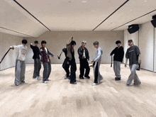 a group of young men are dancing in a large room and one of them is wearing a sweatshirt that says ' chicago '