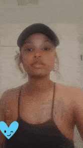 a woman wearing a black hat and a black tank top .