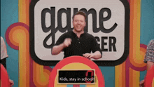 a man in front of a sign that says kids stay in school on it