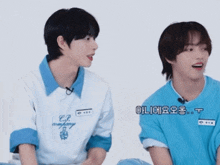 two boys are sitting next to each other and one has a shirt that says c.p. company on it