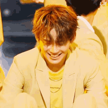 a man wearing a yellow jacket and a yellow shirt that says dro paris smiles