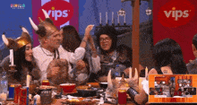 a group of people are sitting at a table in front of a vips logo