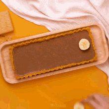 a chocolate tart with a banana slice on top of it