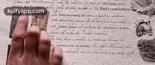 a hand is holding a piece of paper that says " kulfyapp.com " on it