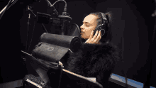 a woman wearing headphones is singing into a microphone that says hp on it