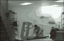 a man is kneeling on a treadmill in a basement with 4gifs.com written on the bottom right