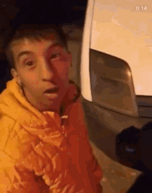 a man in a yellow jacket is standing next to a white van .
