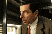 a man in a suit and tie looks surprised in front of a sign that says 0300