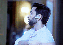 a man with a beard is wearing a pair of wireless headphones .