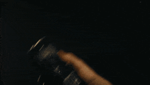 a man with a beard is holding something in his hand in the dark